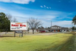 a sign for a sunset motel in front of a building at Sunset Motel and RV in Alliance