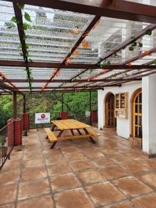 a picnic table under a pergola on a patio at Mangat Farm, Kanatal in Kanatal