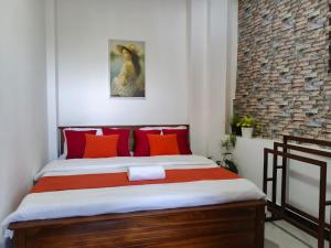 a bedroom with a bed with orange and red pillows at Roo Heaven Villas in Haputale