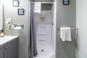 a bathroom with a shower and a toilet and a sink at Sunset Motel and RV in Alliance