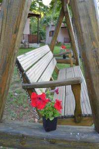 a planter with red flowers sitting next to a bench at Dodis Village in Platanias