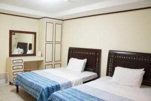 a bedroom with two beds and a mirror at OYO 1202 Shilla Hotel in Pampang +26 photos