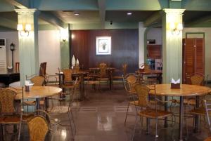 a restaurant with wooden tables and chairs in a room at OYO 1202 Shilla Hotel in Pampang