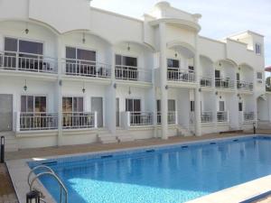 a large white building with a swimming pool in front of it at OYO 1202 Shilla Hotel in Pampang