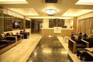 Hotel Nk Grand Park Airport Hotel في تشيناي: لوبي فيه كنب وغرفة انتظار