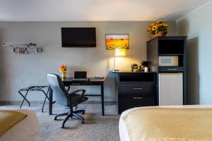 a hotel room with a desk and a computer in a room at Sunset Motel and RV in Alliance +23 photos