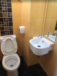 a bathroom with a toilet and a sink at The Northeast Hotel in Si Sa Ket