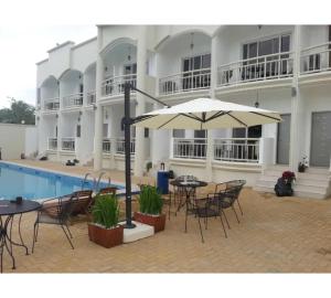 a courtyard with tables and chairs and an umbrella at OYO 1202 Shilla Hotel in Pampang