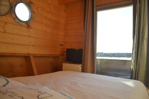 Un dormitorio con una cama con ventana y un televisor. en Different Holidays, en Saumur