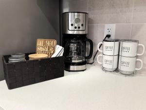 a kitchen counter with two coffee mugs and a blender at Relax, Recharge, Repeat 2Bedroom Walkout Haven in Calgary