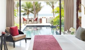 a hotel room with a balcony overlooking the ocean at Al Baleed Resort Salalah by Anantara in Salalah