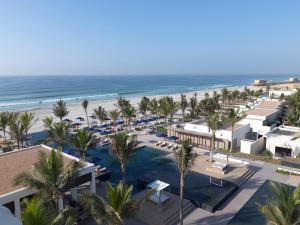a beach with palm trees and palm trees at Al Baleed Resort Salalah by Anantara in Salalah