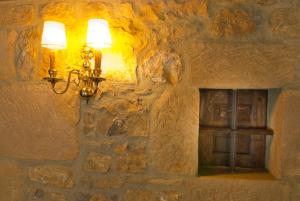 a light shines on a wall in a dimly lit room at La Casa del Organista in Santillana del Mar