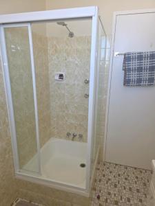 a shower with a glass door in a bathroom at Crystal Waters 7 Ocean Corridor Views, Restaurants, Town Centre in Forster +14 photos