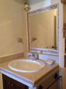 a bathroom with a sink and a large mirror at La Casa di Via Lungomare in Santa Marina Salina