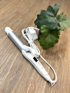 a white hair dryer on a table next to a green plant at Guest House Re-worth Yabacho1 202 in Nagoya