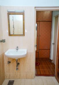 a bathroom with a sink and a mirror and a door at Olive Nest- Tirupati Bus Stand- 300 Meters, Railway Station- 400 Meters in Tirupati +54 photos