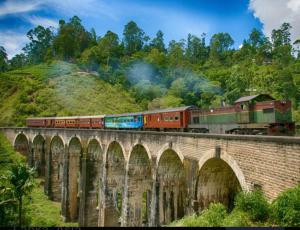 a train on a bridge with a train at Skyline & bitcoin coffee lodge in Kalutara +124 photos