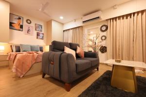 a living room with a couch and a bed at BlancHaus Stays - Premium Luxury I Viman Nagar I Near Pune Airport I Skyline View in Pune