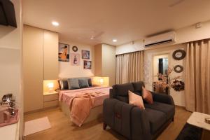 a bedroom with a bed and a couch at BlancHaus Stays - Premium Luxury I Viman Nagar I Near Pune Airport I Skyline View in Pune