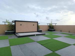 a courtyard with green grass and a building at BlancHaus Stays - Premium Luxury I Viman Nagar I Near Pune Airport I Skyline View in Pune