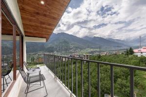 a balcony with chairs and a view of mountains at Echor Himalayan Aurum Resort & Spa, Manali in Manāli