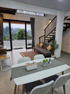 a living room with a couch and a table and chairs at Naava Village in Tagalbato