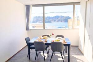 a dining room with a table and chairs and a window at Magokoro House 201 in Nishiizu