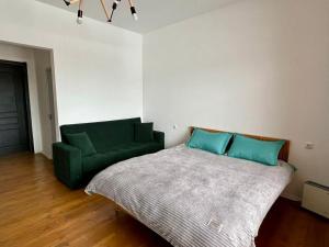 a bedroom with a bed and a green couch at Bazaleti Heaven in Bazalet'i