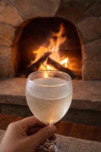 a person holding a wine glass in front of a fireplace at Apu House in Calca