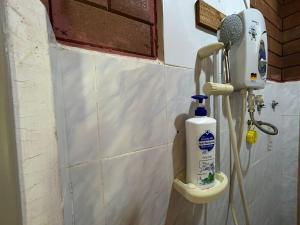 a bathroom with a soap dispenser on a toilet at Homestay Sani in Tanah Merah