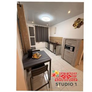 a kitchen with a table and a counter top at Kahaia stay lodge in Papeete