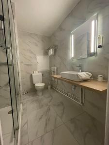 a bathroom with a sink and a toilet at Cit'Hotel LA PYRAMIDE in Romorantin +24 photos