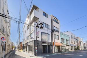 a white building on the side of a street at Matcha Inn Sakura Tokyo in Tokyo