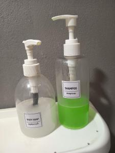 two bottles of soap sitting on top of a sink at Row House Long Beach in Ko Lanta