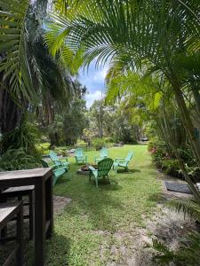 a group of green chairs in a park with palm trees at Cowan Lodge in Cowan Cowan