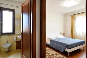 a bedroom with a bed and a bathroom with a sink at Sa Omu Bianca in Tortolì +93 photos