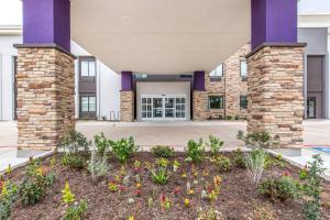 a building with flowers in front of it at Sleep Inn Dallas Love Field-Medical District in Dallas