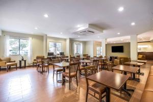 a restaurant with tables and chairs and a flat screen tv at Sleep Inn Dallas Love Field-Medical District in Dallas