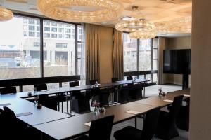 a conference room with tables and chairs and large windows at Thompson Chicago, by Hyatt in Chicago