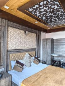 a bedroom with a large bed with a wooden ceiling at Golden Glow Stays in Shimla