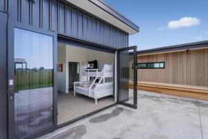 a balcony with sliding glass doors on a building at Lakeside Retreat Matarangi - Deluxe Home with Sleep-out in Whitianga