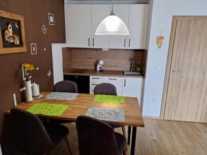 a kitchen with a wooden table with chairs and a dining room at Apartma San Izola - near the beach San Simon in Izola