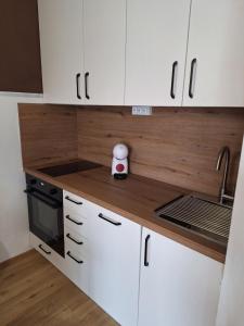 a kitchen with white cabinets and a stove top oven at Apartma San Izola - near the beach San Simon in Izola