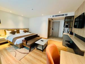 a hotel room with a large bed and a table at Hyphen Business Hotel in Noida +130 photos