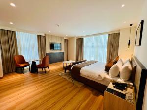 a hotel room with a bed and a table and chairs at Hyphen Business Hotel in Noida