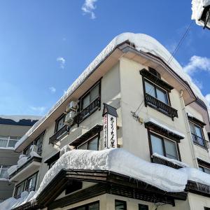 a building with snow on the side of it at Chouchinya in Nozawa Onsen
