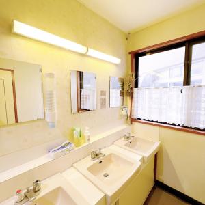 a bathroom with two sinks and a mirror at Chouchinya in Nozawa Onsen