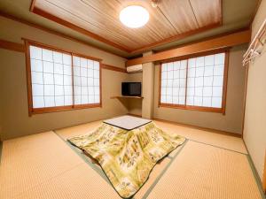 a room with a bed in a room with windows at Chouchinya in Nozawa Onsen