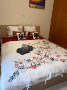 a bed with a flowery comforter and shoes on it at Larnaca Beach Apartment in Larnaca